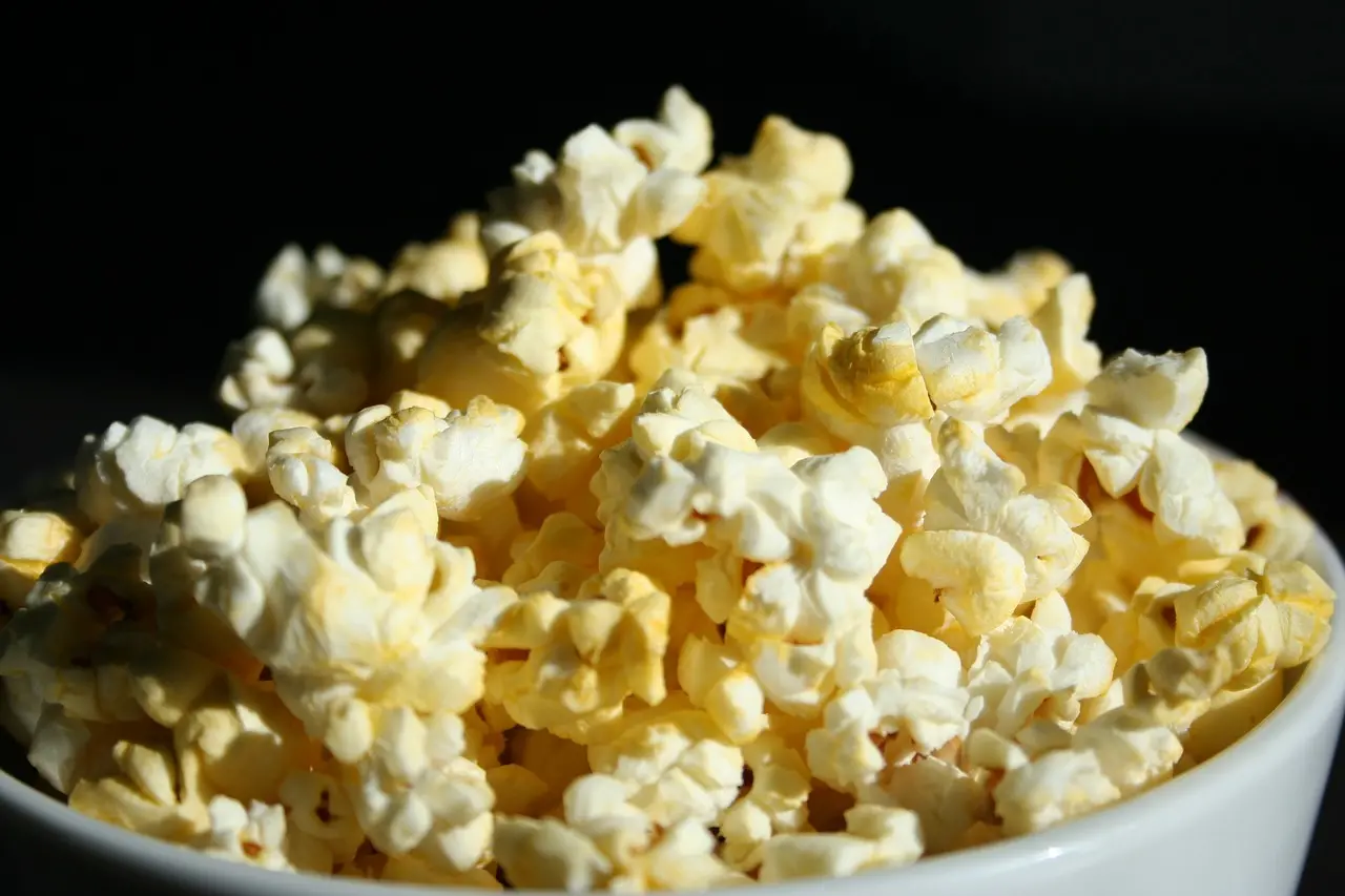 Popcorn i en skål, mörk bakgrund.